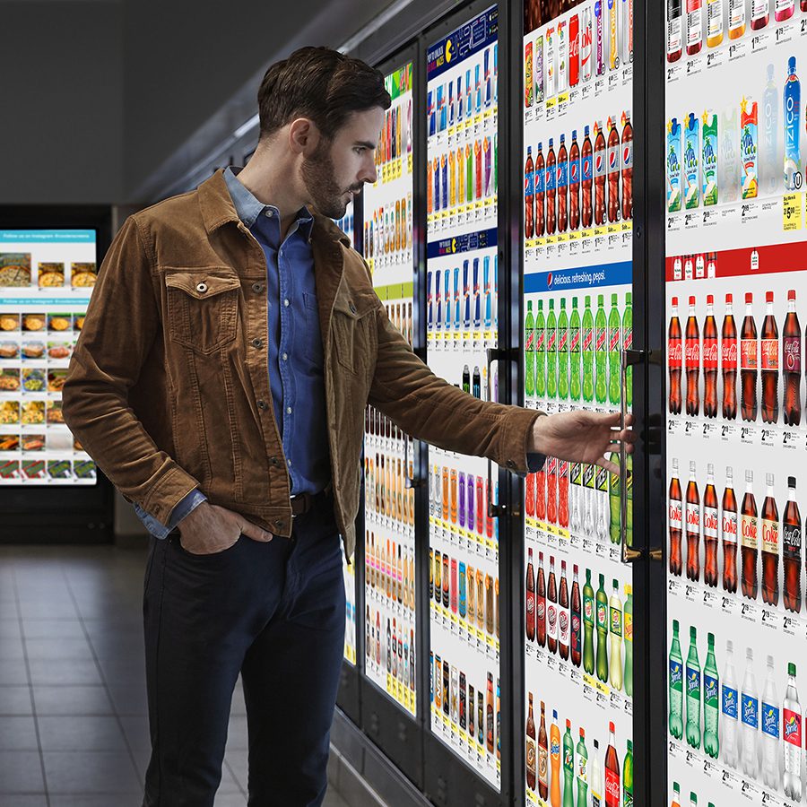 Man at Cooler Screens refrigerator display.