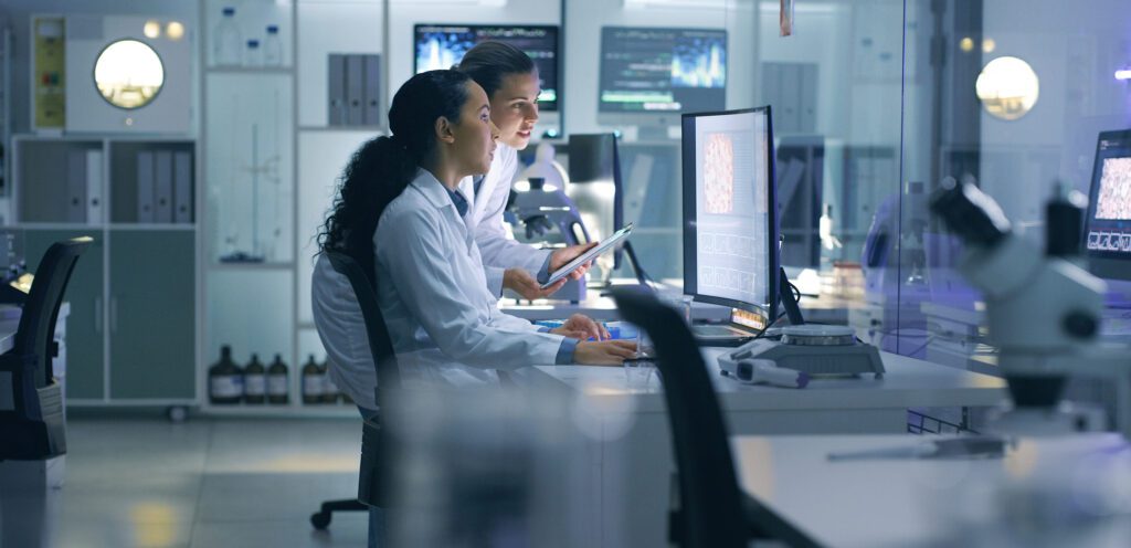 Women review brain scan images in life science lab. Women review brain scan images in life science lab.