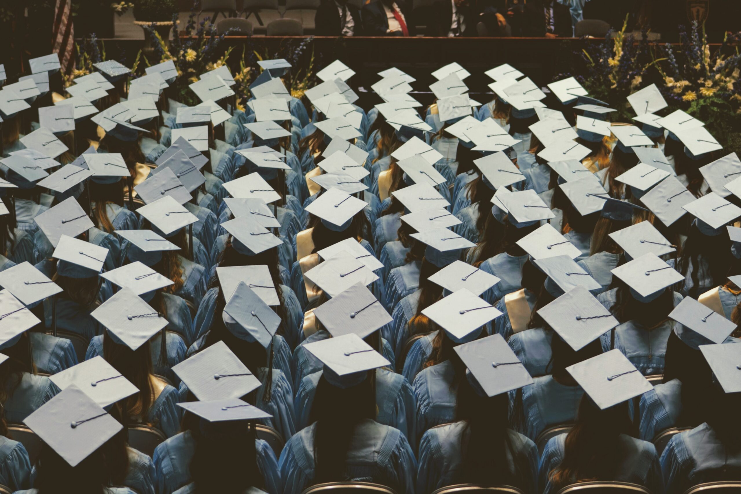 Graduates in caps and gowns seated at ceremony.