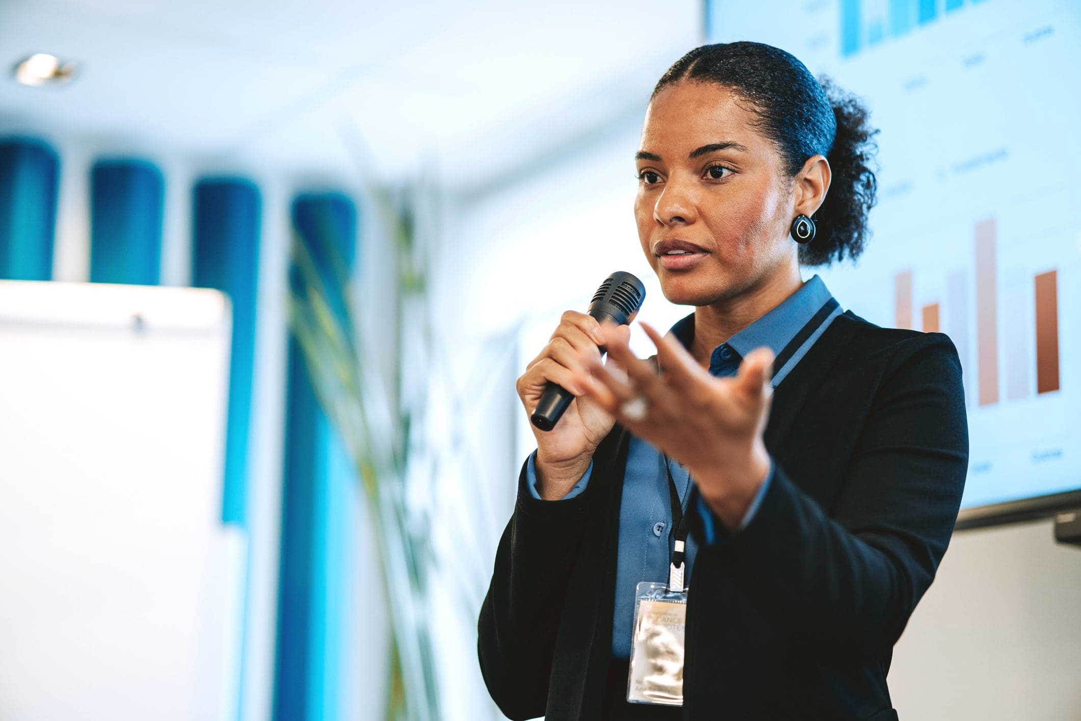 Speaker gestures, holding mic.