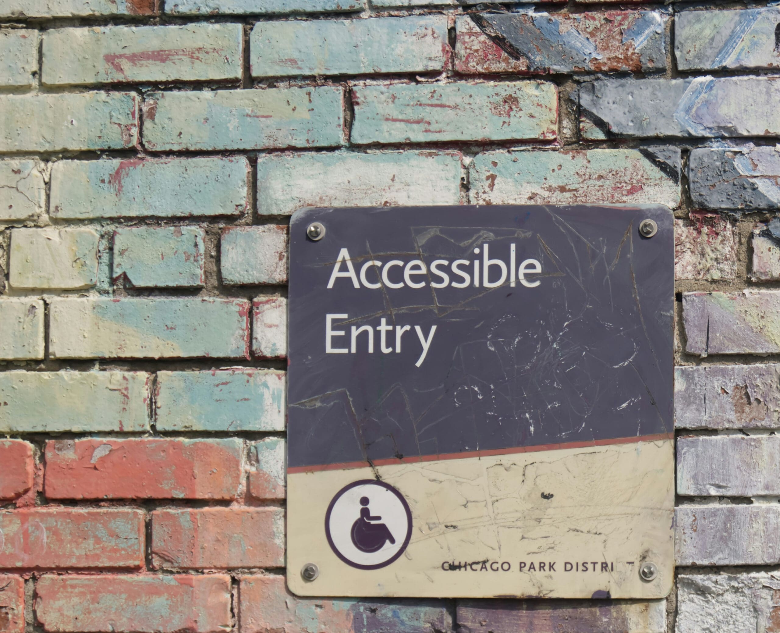 Chicago Park District accessible entry sign along painted wall.
